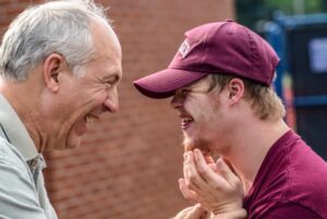 two men speaking and smiling