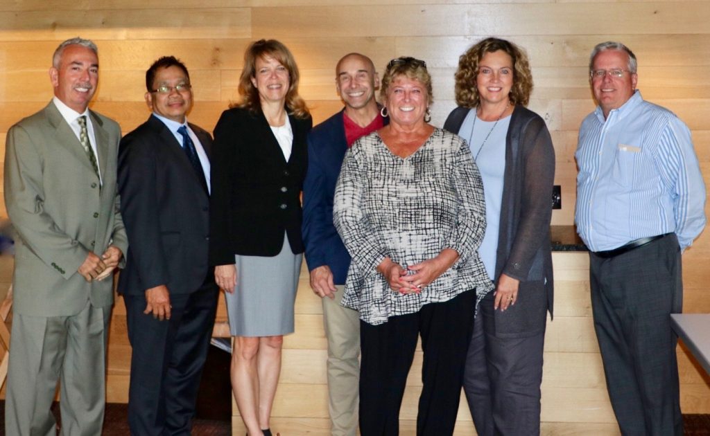 board members against a wood backdrop