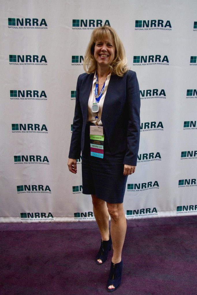 woman in buisness suit with "NRRA" backdrop