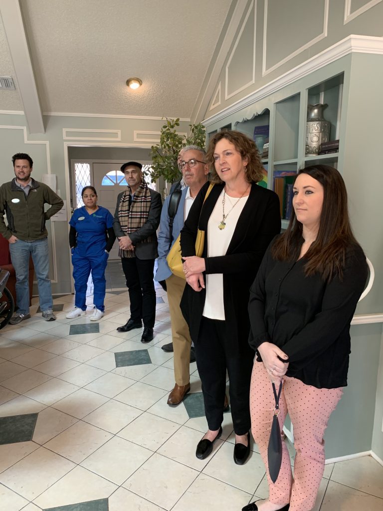 board members standing in lobby of care facility