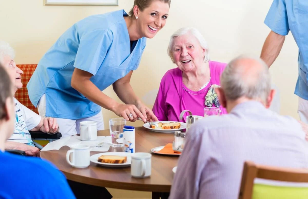 smiling nurse serving seniors food