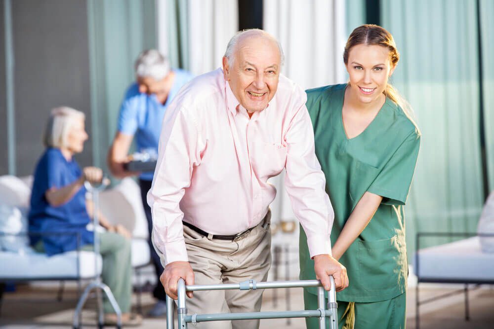 man with walker being helped by nurse